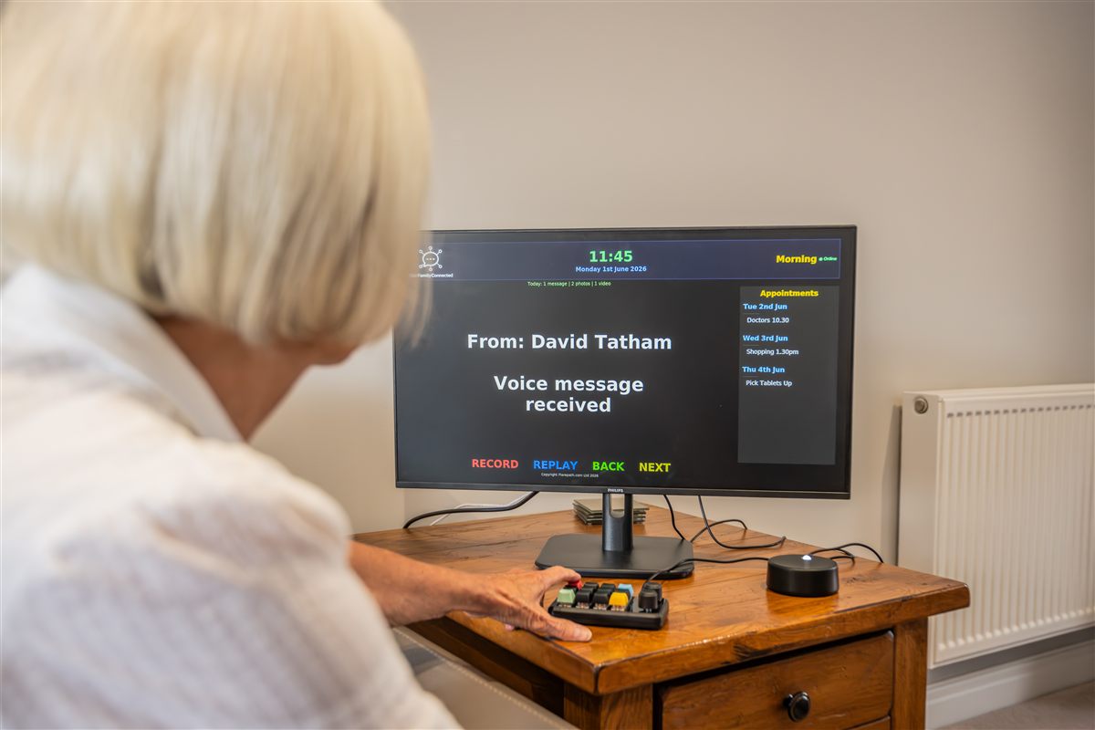 Elderly woman using OurFamilyConnected with the coloured keypad